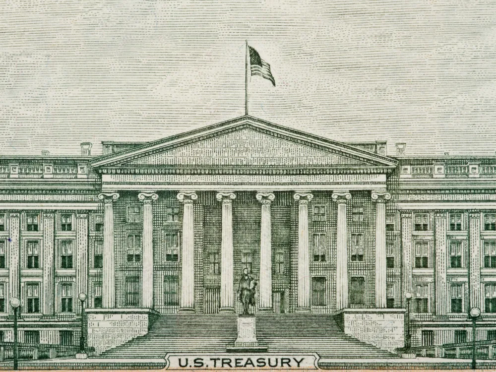 Illustration of the U.S. Treasury building, featuring a grand facade with columns, steps, and an American flag waving above.