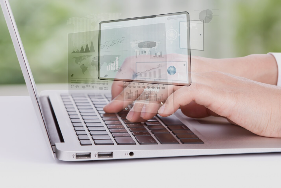 A person types on a laptop, with digital graphs and charts overlaid, illustrating data analysis and technology use.