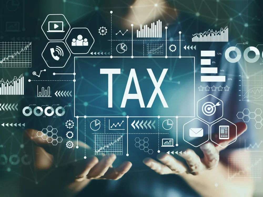 Digital tax concept with the word “TAX” surrounded by financial charts, analytics icons, and data visualizations above open hands.