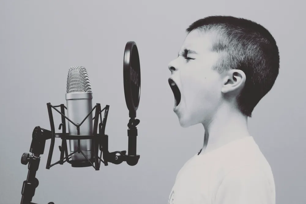 Boy screaming into a voice over microphone