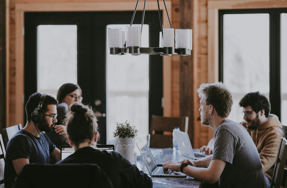 Developers working behind a shared table in an open work space. 