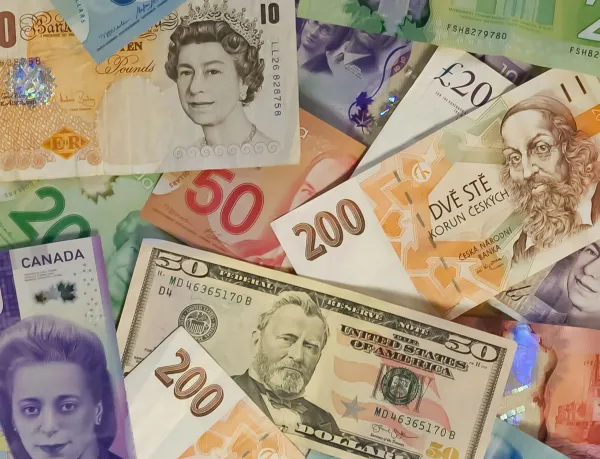 A colorful assortment of various banknotes from different countries, including British pounds, Canadian dollars, and U.S. dollars.