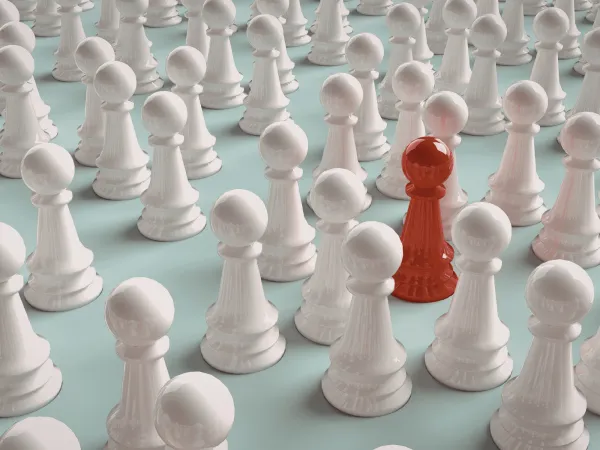 A grid of glossy white chess pawns arranged in rows, with one red pawn standing out prominently among them, symbolizing differentiation or uniqueness within a competitive group.